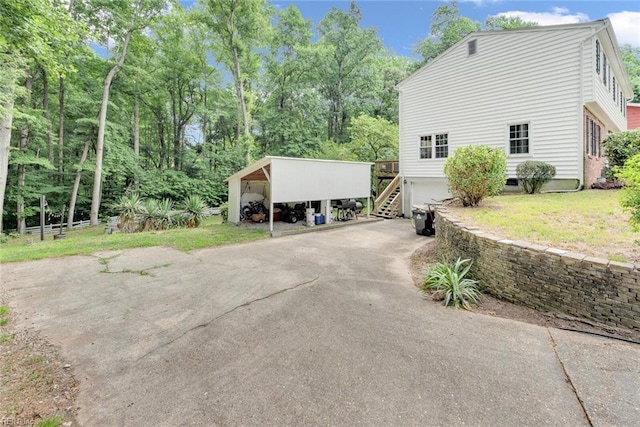 view of side of home featuring a lawn and a carport