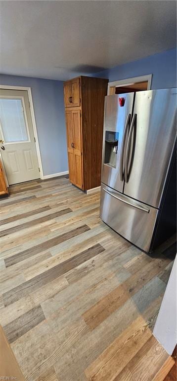 kitchen featuring light hardwood / wood-style flooring and stainless steel fridge with ice dispenser