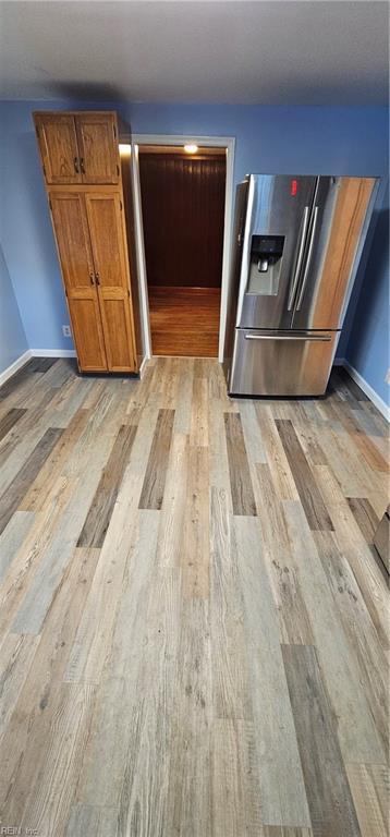 kitchen with stainless steel fridge and light hardwood / wood-style flooring