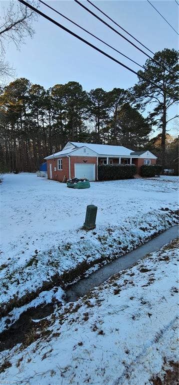 yard covered in snow featuring a garage