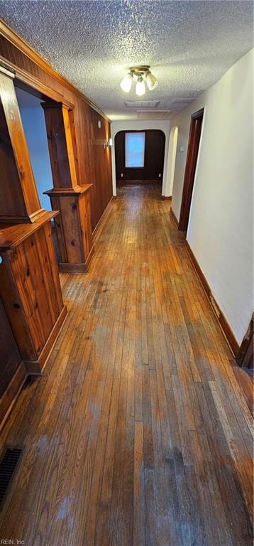 hall with hardwood / wood-style floors and a textured ceiling