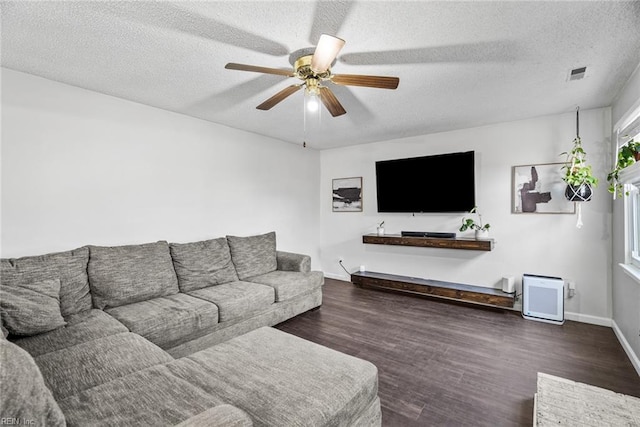 living room with ceiling fan, dark hardwood / wood-style flooring, and a textured ceiling