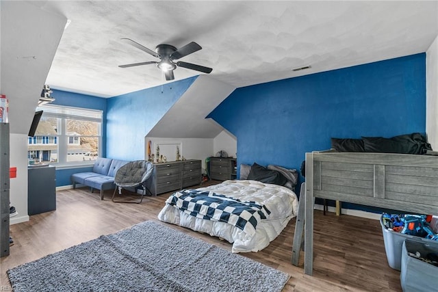 bedroom with ceiling fan, wood-type flooring, and lofted ceiling