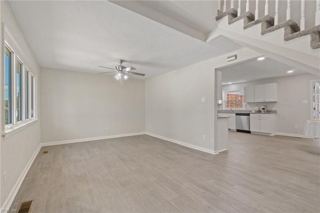 unfurnished living room with light wood-type flooring and ceiling fan