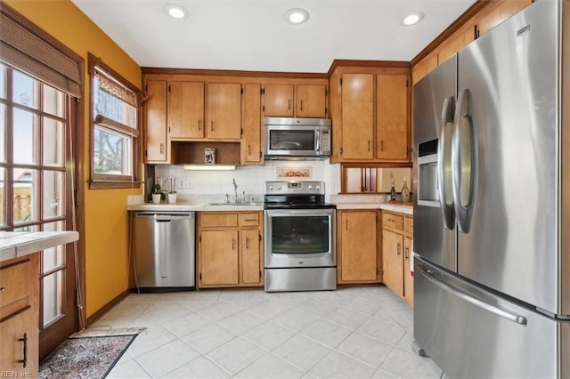 kitchen featuring light tile patterned flooring, stainless steel appliances, sink, and backsplash