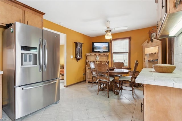 tiled dining area with ceiling fan