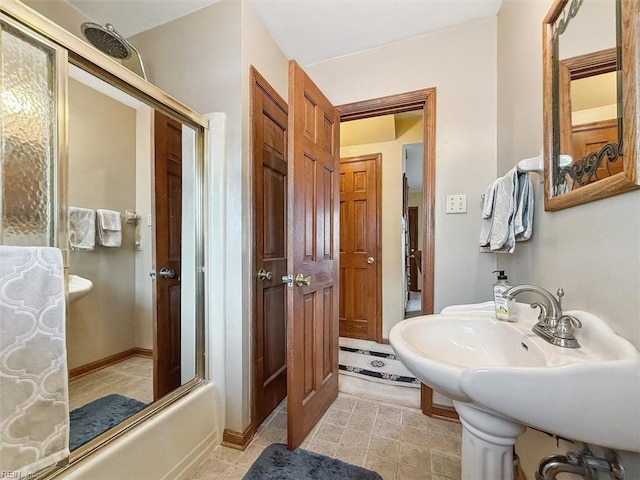 bathroom with sink and combined bath / shower with glass door