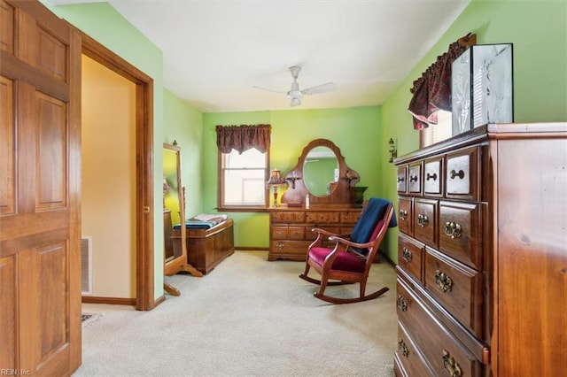 living area with ceiling fan and light colored carpet