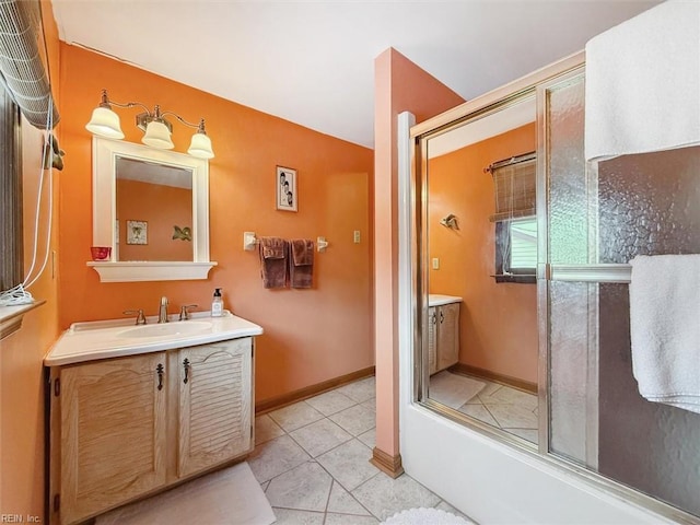 bathroom featuring vanity, tile patterned flooring, and enclosed tub / shower combo