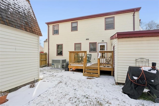 snow covered property featuring a wooden deck and central AC