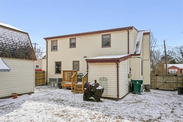 snow covered rear of property with central AC unit