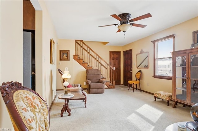 living area with light colored carpet and ceiling fan