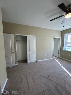 unfurnished bedroom with dark colored carpet and ceiling fan