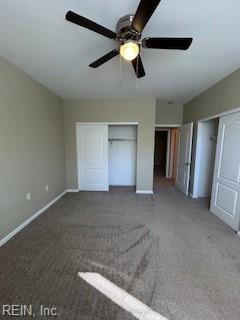 unfurnished bedroom with ceiling fan and dark colored carpet