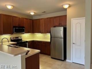 kitchen with appliances with stainless steel finishes, kitchen peninsula, sink, and a breakfast bar area