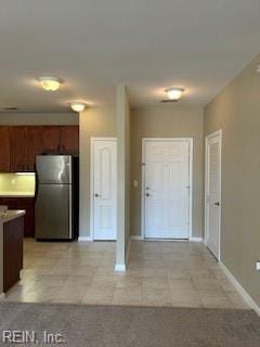 kitchen featuring light tile patterned floors and stainless steel refrigerator