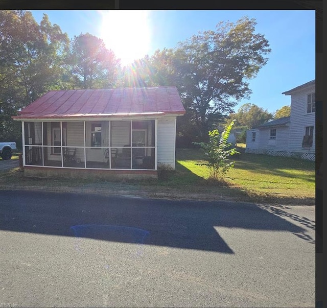 view of front of house featuring a front yard and a sunroom