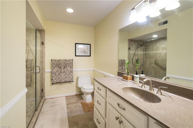 bathroom featuring a shower with door, vanity, tile patterned floors, and toilet