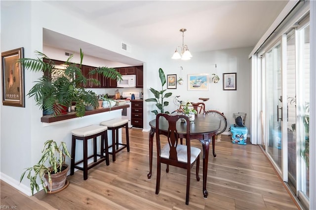 dining room with a chandelier and light wood-type flooring