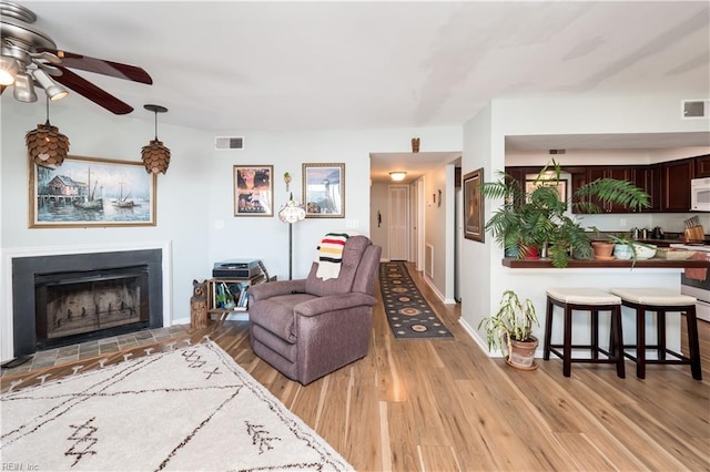 living room featuring ceiling fan and light wood-type flooring