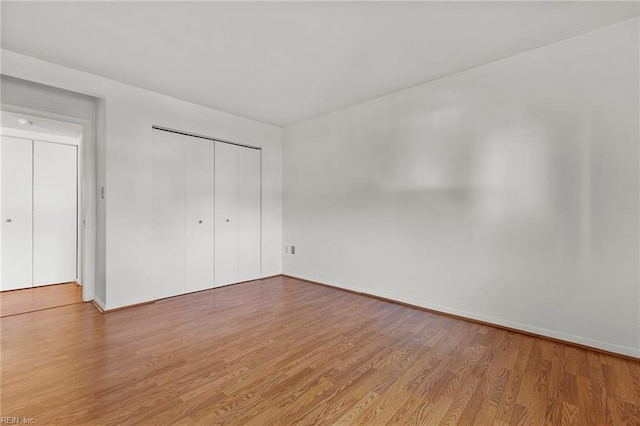 unfurnished bedroom featuring hardwood / wood-style floors and a closet