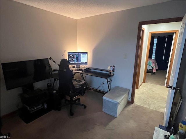 carpeted home office featuring a textured ceiling