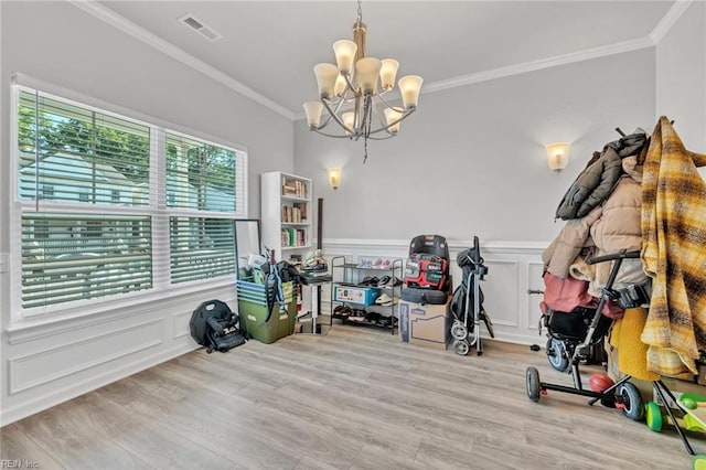 interior space with crown molding, light hardwood / wood-style floors, and a chandelier