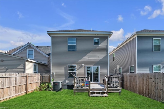 back of house featuring cooling unit, a wooden deck, and a lawn