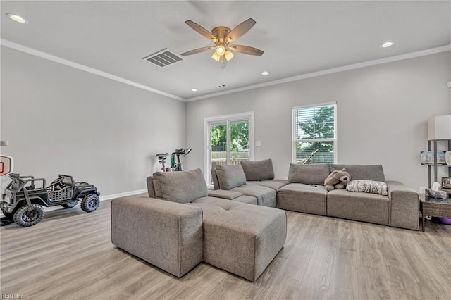 living room with light hardwood / wood-style flooring, ornamental molding, and ceiling fan