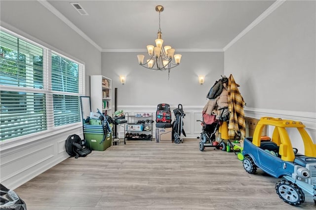 interior space featuring ornamental molding, a chandelier, and light hardwood / wood-style flooring