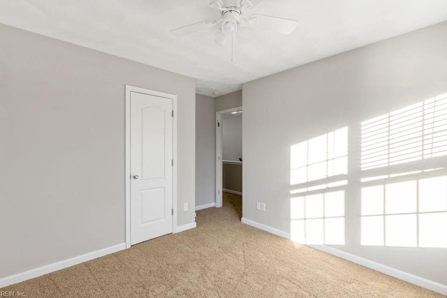 empty room with light colored carpet and ceiling fan