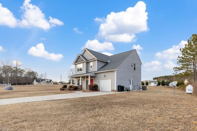 view of front of house with a garage, a front yard, and central AC unit