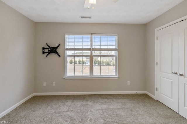 carpeted empty room featuring ceiling fan