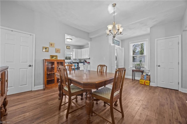 dining space featuring dark hardwood / wood-style floors and a chandelier