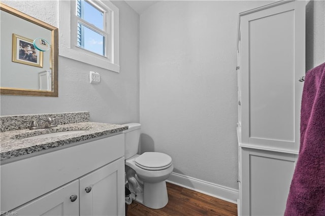 bathroom featuring hardwood / wood-style flooring, vanity, and toilet