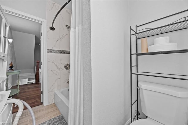 bathroom with hardwood / wood-style flooring and shower / bath combo with shower curtain