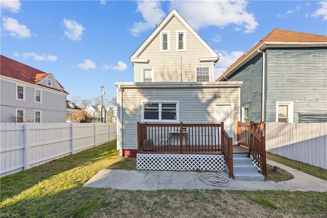 back of house featuring a wooden deck and a lawn