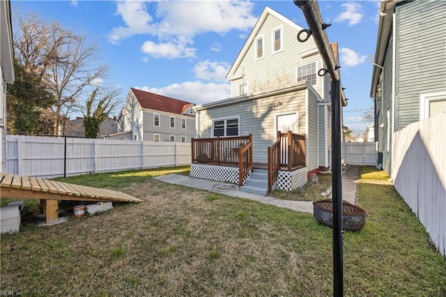 rear view of property featuring a yard and a deck