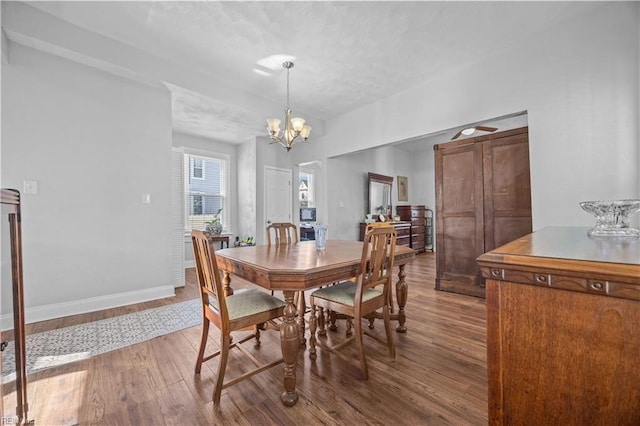 dining area with hardwood / wood-style flooring and a notable chandelier