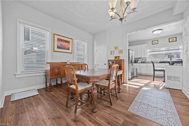 dining space with an inviting chandelier, wood-type flooring, and sink