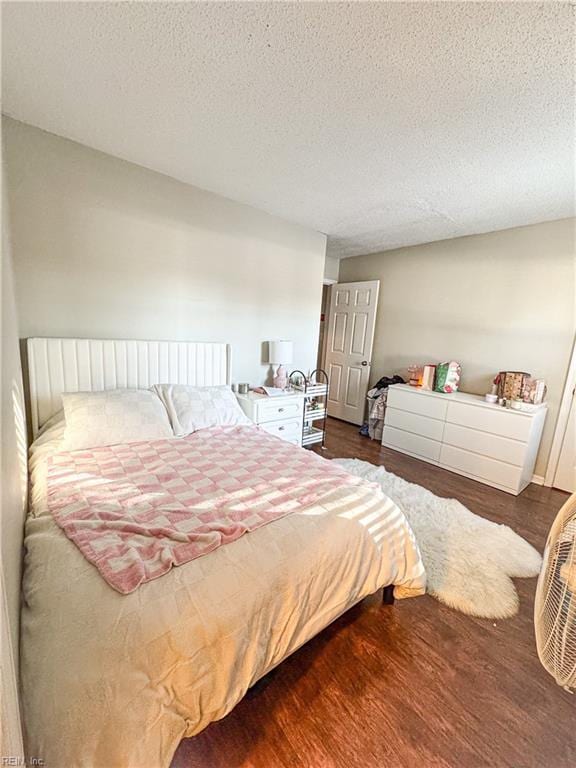 bedroom with a textured ceiling and dark hardwood / wood-style floors