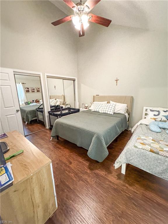 bedroom featuring a closet, dark hardwood / wood-style floors, a high ceiling, and ceiling fan