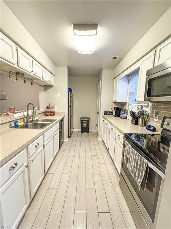 kitchen featuring sink, white cabinets, and appliances with stainless steel finishes