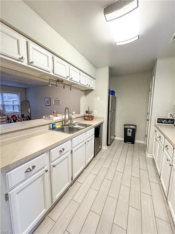 kitchen with sink, white cabinetry, and dishwasher