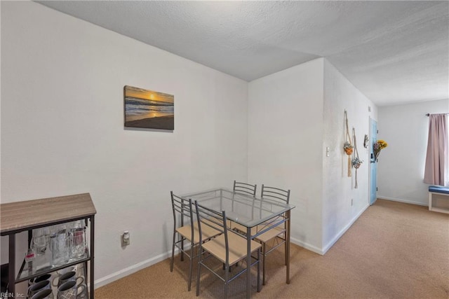 dining area with carpet and a textured ceiling