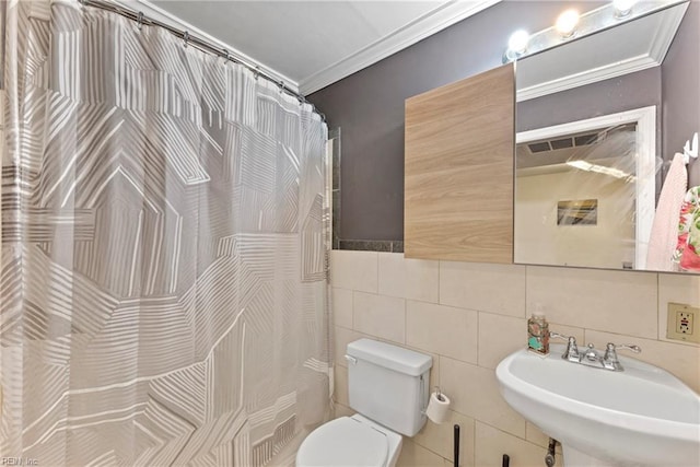 bathroom with crown molding, toilet, sink, and tile walls