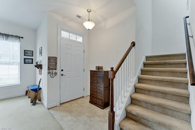 carpeted foyer entrance featuring a wealth of natural light