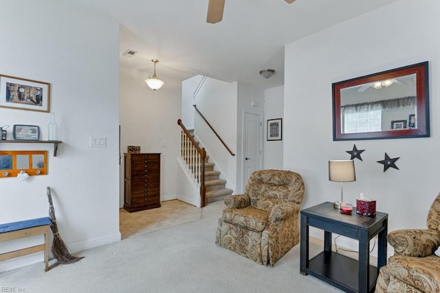 living area with ceiling fan and light colored carpet