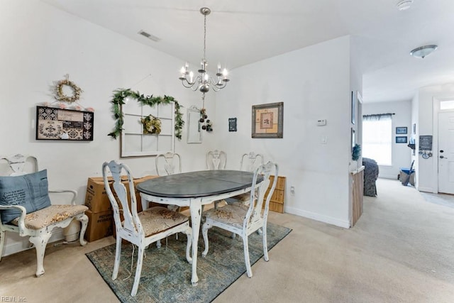 dining room featuring a notable chandelier and light colored carpet