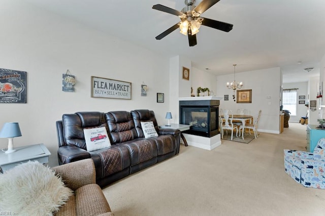 living room featuring ceiling fan with notable chandelier, a multi sided fireplace, and light carpet